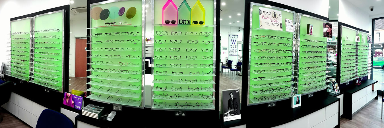 The backlit green frame display wall inside Bath Opticians at 57 Moorland Road, Oldfield Park
